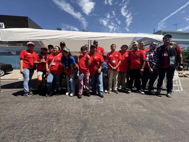 HLAT volunteer team in matching red shirts under an outreach canopy